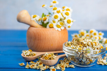 Obraz na płótnie Canvas Dry chamomile flowers on a wooden table. Soothing chamomile tea. Herbal drink. flat layout. Space for text.Copy space.Medical prevention and immune concept. Folk alternative medicine.