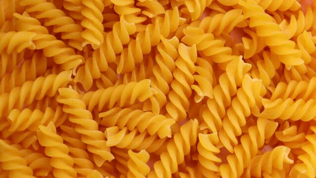 dry pasta fusilli , rotation in circle. dry spirals Turning. selective focus. 
