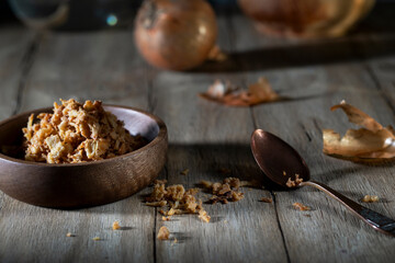 Fried onions in a wooden bowl on a rustic table