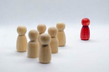 Red wooden figure leading other wooden figures reaching. Leadership concept