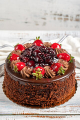 Cake with whipped cream, chocolate and fruit. Birthday cake on white background
