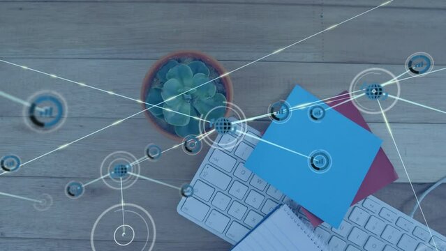 Animation of network of digital icons over close up of memo notes, plant, keyboard on wooden table