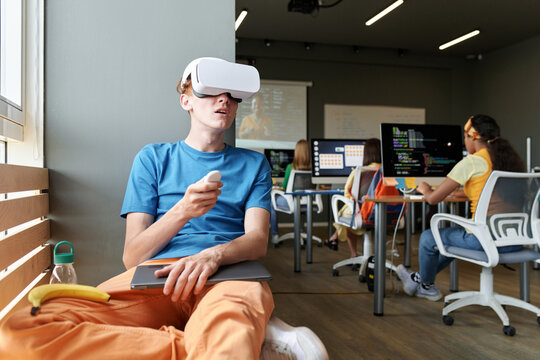 Student using VR glasses while sitting at lesson in the classroom