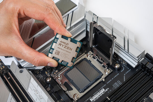 Uzhgorod, Ukraine - August 28, 2023: Manual installation of the AMD Ryzen 9 7950X3D processor into the motherboard.