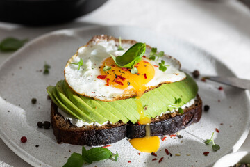 Breakfast wirh toast with avocado and eggs on a plate
