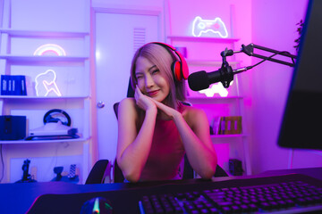 Young Asian woman pro gamer have online live streaming, Pretty girl singing and chatting with her fans at home, Excited woman wearing headset to live streaming broadcast games challenge social media