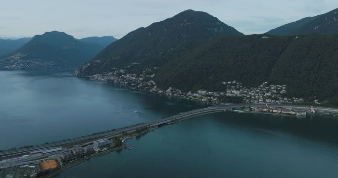 Aerial view of a road crossing the Lugano lake at sunset, Melide, Ticino, Switzerland.