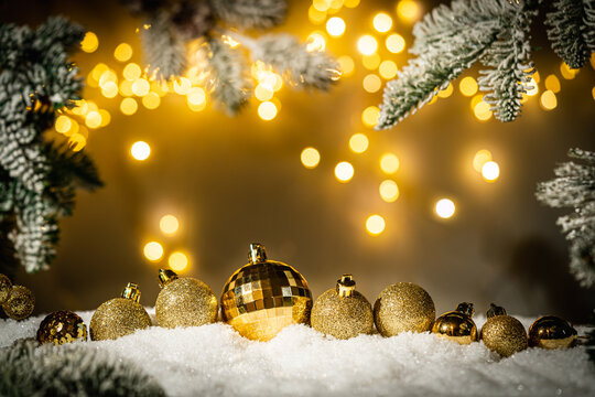 Christmas Holiday background with snow, fir tree and decorations with christmas light behind