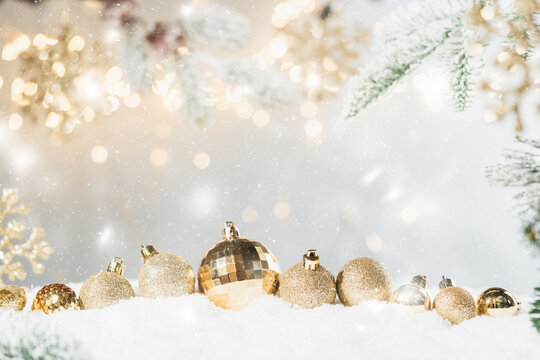 Christmas Holiday background with snow, fir tree and decorations with christmas light behind