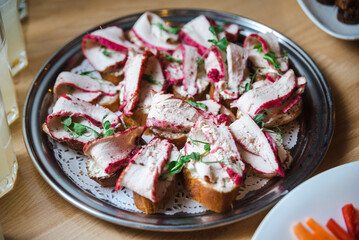bruschetta with chicken breast meat dyed in beetroot and garnished with pea microgreens on a plate