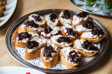 Toasts with tuna cream cheese spread and caramelized onions on a plate.