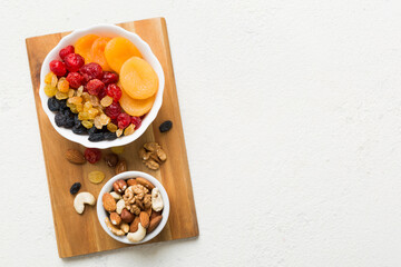 healthy snack: mixed nuts and dried fruits in bowl on table background, almond, pineapple, cranberry, cherry, apricot, cashew