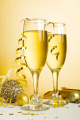Champagne glasses and christmas decor on colored holiday background. Flat lay New Year decorations