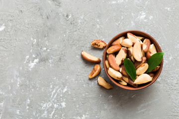 Fresh healthy Brazil nuts in bowl on colored table background. Top view Healthy eating bertholletia concept. Super foods
