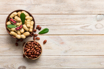 Fresh healthy peanuts in bowl on colored table background. Top view Healthy eating bertholletia concept. Super foods