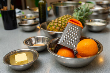 Close-up of grater, butter, oranges and ingredients for making a citrus pie