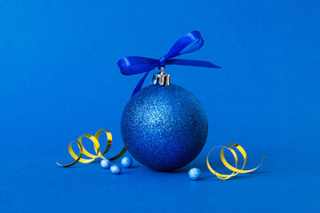 Christmas ball on colored background. decoration bauble with ribbon bow with copy space