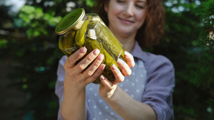 A woman prepares canned vegetables for the winter. On a warm autumn day, the hostess does household...