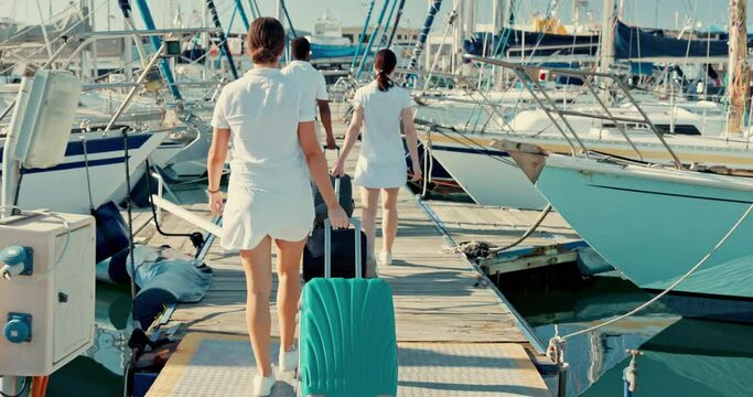 Boat port, suitcase and back of people walking to travel, vacation and summer trip at ocean. Luggage, pier and crew at ship dock, luxury holiday of tourist and outdoor on wood bridge at yacht at sea