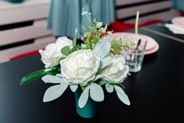 Bouquet of artificial white flowers on a black table in a restaurant