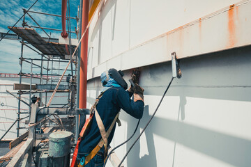 Welding male worker metal is part of machinery plate tank beam pipe construction flash spark external tank