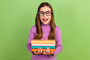 Photo of impressed funky kid with long hairstyle wear purple turtleneck hold book staring open mouth isolated on green color background