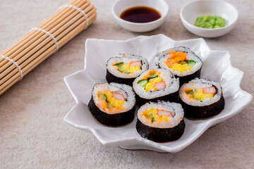 Maki sushi rolls on white plate with soy sauce and wasabi-Japanese food