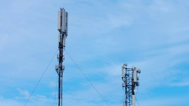 View of cell tower antennas on the blue sky and clouds background. Timelapse. Telecommunication cell phone, radio transmitters of cellular 6g 5g 4g mobile, smartphones, internet. IT. Video Footage 4k.
