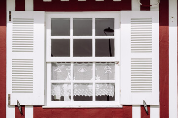 Vintage window with white shutters on a typical red and white striped wall, Costa Nova, Aveiro,...