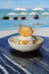 Roasted pineapple with dried pineapple and coconut ice cream by the sea