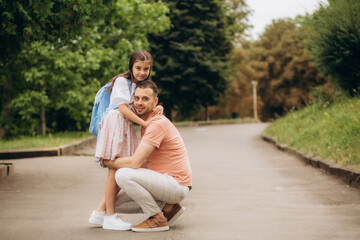 first day at school. father leads a little child school girl in first grade