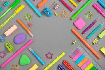 Round frame of colorful rainbow school and office stationery set on gray background. Flatly, copyspace.