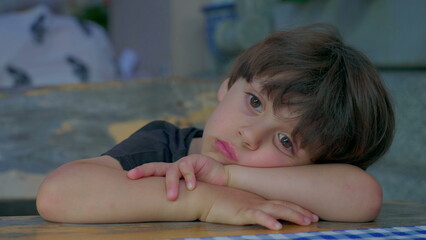 One pensive bored small boy displaying thoughtful expression daydreaming. Kid's boredom, lost in...