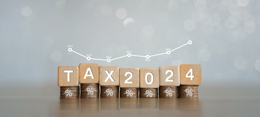 Interest Rates, Inflation and Taxes Place the wooden block on the coin with the Tax 2024 icon with...