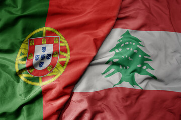 big waving national colorful flag of portugal and national flag of lebanon .