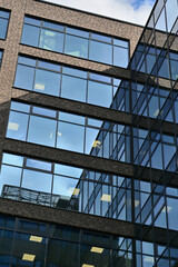 Low-angle view of modern office building with reflections in the windows