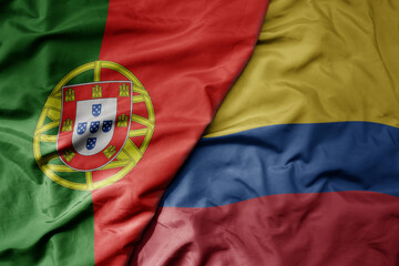 big waving national colorful flag of portugal and national flag of colombia .