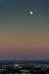 Captivating quarter moonrise over Évora, Portugal's Alentejo region, painting the cityscape with lunar magic.