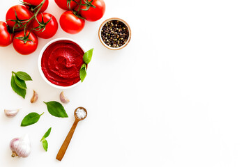 Tomato sauce passata in bowl with fresh tomatoes and basil