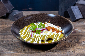 Platillo Enchiladas Suizas con frijoles, queso, cebolla y crema