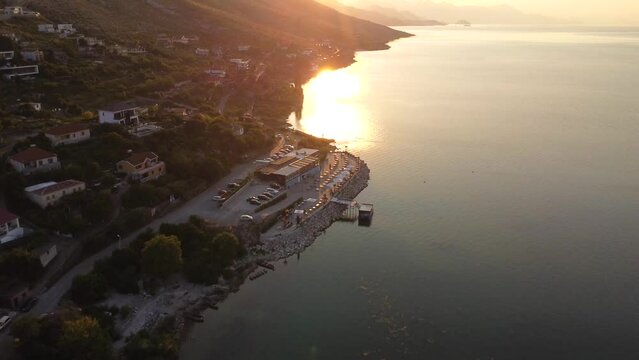 Aerial drone view of Shiroka Lake at sunset and its restaurant area near Shkoder. Albania