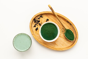 Spirulina algae powder in bowl and cold milk latte drink, top view