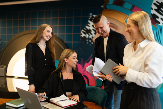 Team gathers to play virtual team challenges for fun. Employees solve quizzes together as teambuilding activity in coworking office area