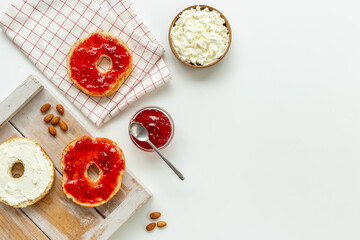 Baked bread bagels with with berry jam and cheese cream. Healthy breakfast background