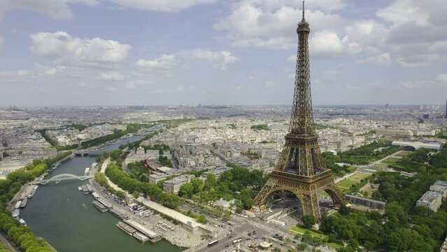 Aerial view of the Eiffel tower on the banks of the river Seine, with the city of paris on the horizon. Cinematic 4k.