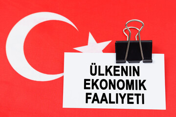 On the flag of Turkey lies a business card with the inscription - economic activity of the country