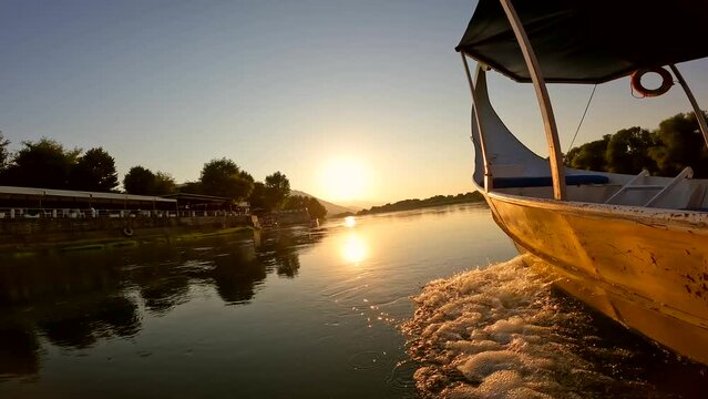 Orange sunset sailing across the lake in a traditional boat on a sightseeing excursion from Shkoder in Shiroka. Albania