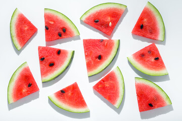 fresh sliced red pieces of watermelon like background, flat lay with hard shadow on white background, creative decoration of summer concept