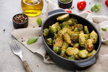Brussels sprouts baked in the oven with salt, pepper and olive oil on grey background. Keto cuisine concept