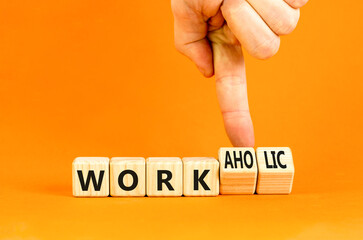 Work or workaholic symbol. Concept words Work or Workaholic on wooden cubes. Beautiful orange table orange background. Businessman hand. Business work or workaholic concept. Copy space.